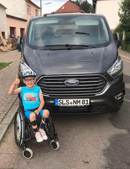 Der 7jährige Moritz S. präsentiert voller Stolz das neue Wunschfahrzeug seiner Familie, das mit Rollstuhlrampe im Heck ausgestattet ist und endlich mehr Mobilität für die ganze Familie bedeutet