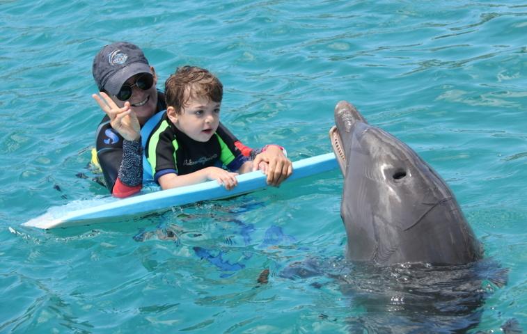 Das Foto zeigt Raoul bei seiner Delfintherapie 2019 mit seiner Therapeutin und 'seinem Delfin Nuri' (Bildrechte: Klaus Port)